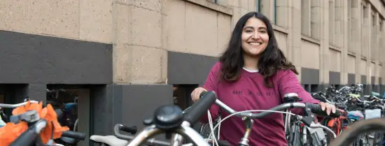 The ISS student in front of the ISS building with the bike