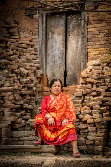 Woman sitting in front of a building under reconstruction in Bhaktapur, 2017, Nepal