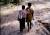 Children walking barefoot in forest (cut)