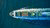 Colourful cargo boat headed out to sea - aerial view