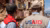Two USAID workders in front of a bombed out house