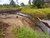 Extraction pipe running through a small river surrounded by fields