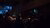 A crowd sits and watches speakers on stage in a large auditorium.