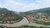 The image shows the Kura and Aragvi rivers converging into one another. In the background is also lush greenery, mountains and homes.