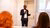 Kwasi Boahene, wearing a black suit and white button up shirt, gives a presentation to audience during a workshop