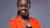 Portrait photo of researcher Vivienne Sserumaga Mulema wearing a bright red blazer with a gray background.
