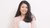 Melisa Try Hatmanti sits for a portrait photo against a off-white backdrop