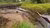 Extraction pipe running through a small river surrounded by fields