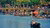 Photograph of crowded riverside canal with tourists paddling in wooden boats
