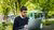 Student sitting outside looking on computer screen - Woudestein campus
