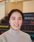 Recent graduate, Moet Toyoda is sitting on the stairs
