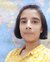 Person in yellow polka-dot shirt standing in front of a world map