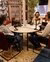 Three people with headphones sitting around a table speaking into microphones