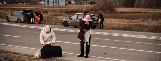 Ukrainian refugees standing on the side of a motorway