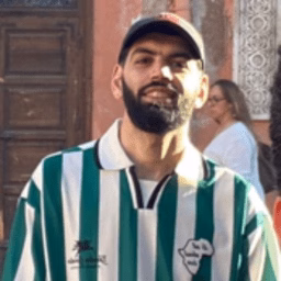 Man smiles wearing hate and striped jersey